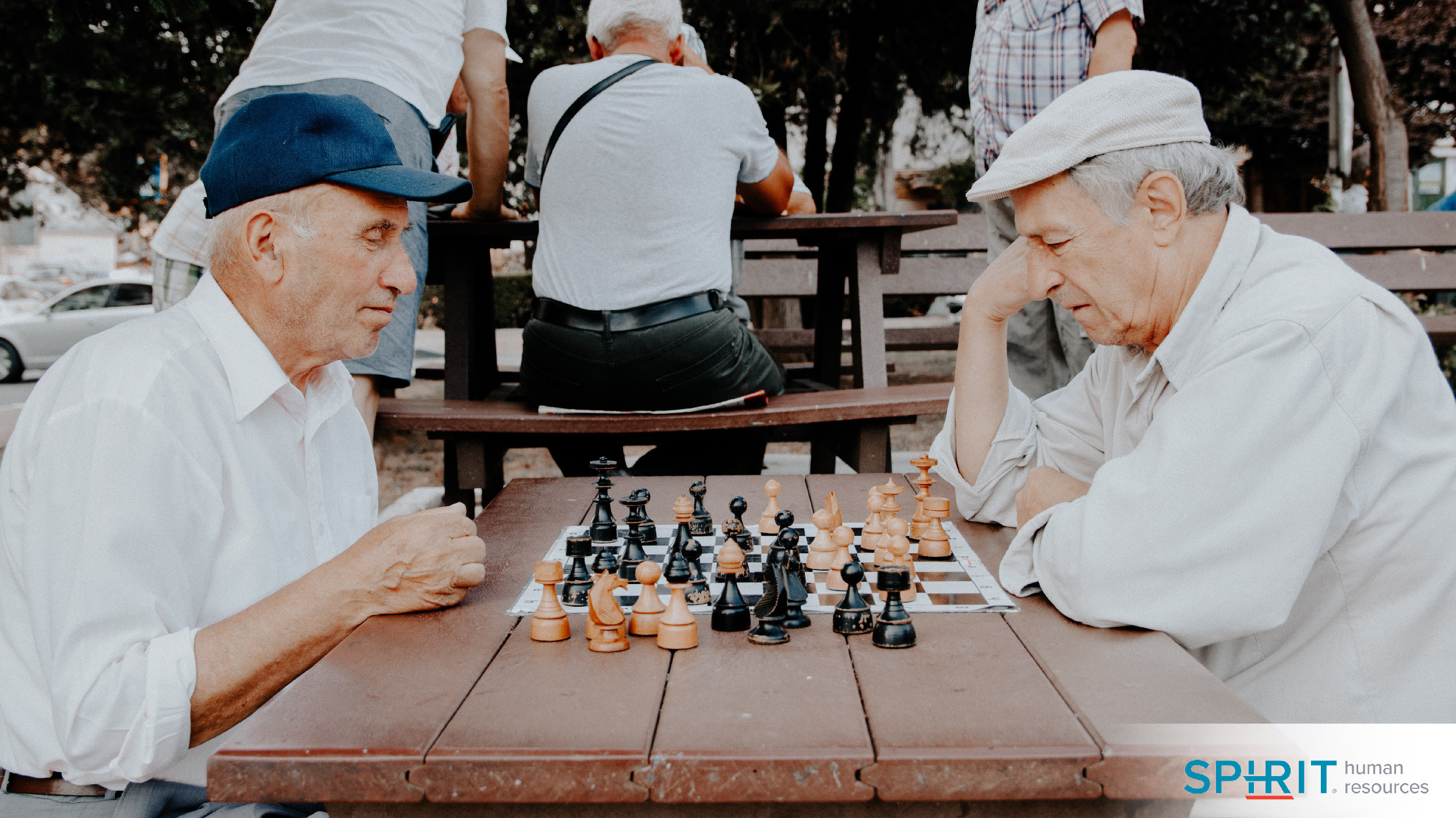 two men playing chess in a park